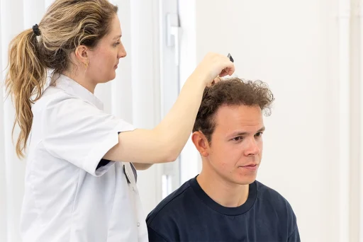 Man van jonge leeftijd die voorbereid wordt voor een haartransplantatie